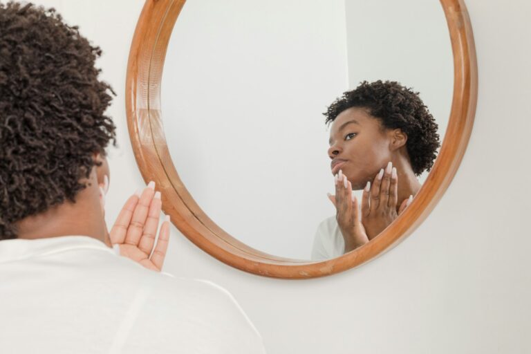 Woman checking her facial skin in a mirror