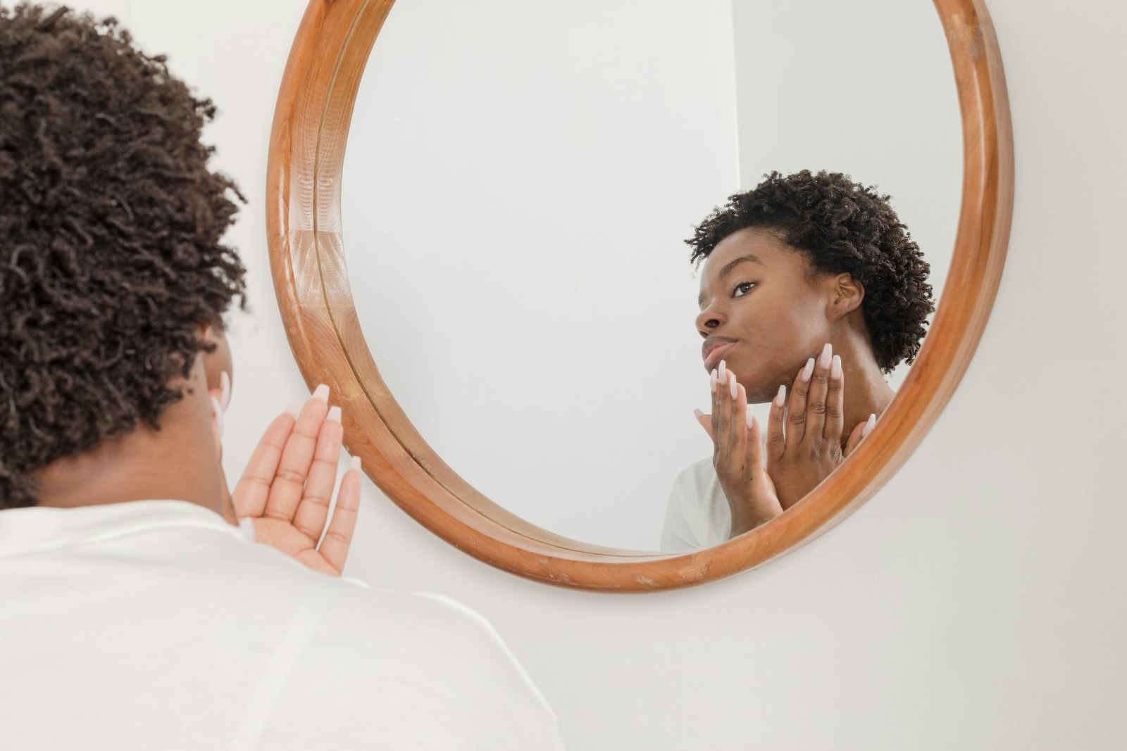 Woman checking her facial skin in a mirror